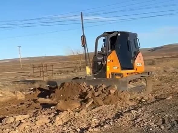 Cargadora de orugas limpiando y nivelando un lote