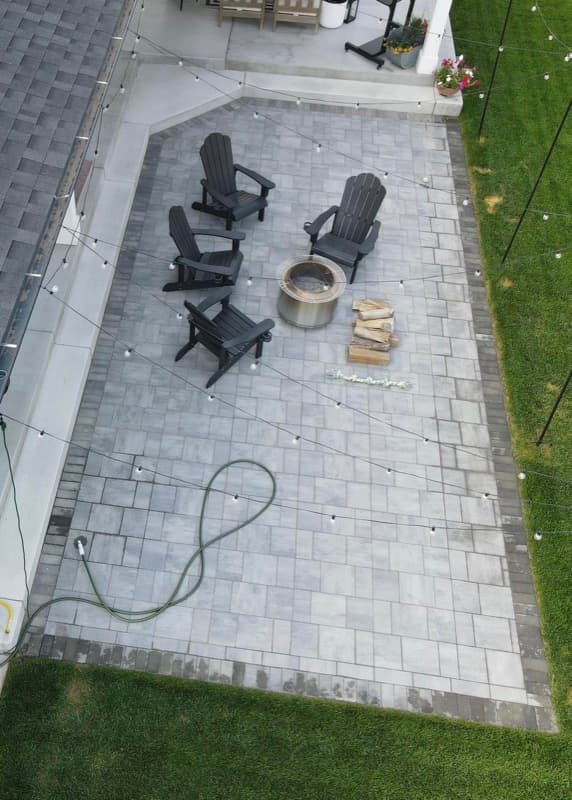 Paver patio with a fire pit and Adirondack chairs