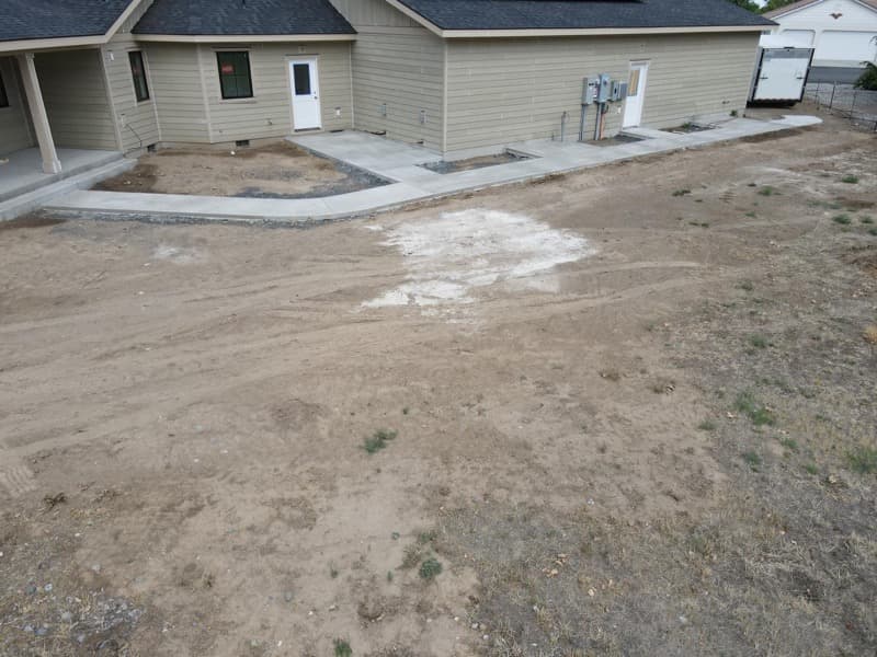 Side yard with new concrete walkways, before landscaping