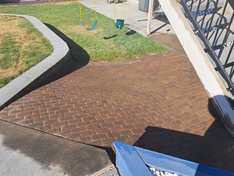 Concrete curbing and a stamped concrete patio beside a lawn