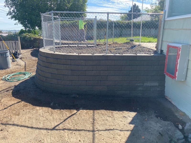 Curved block retaining wall rebuilt beside a home