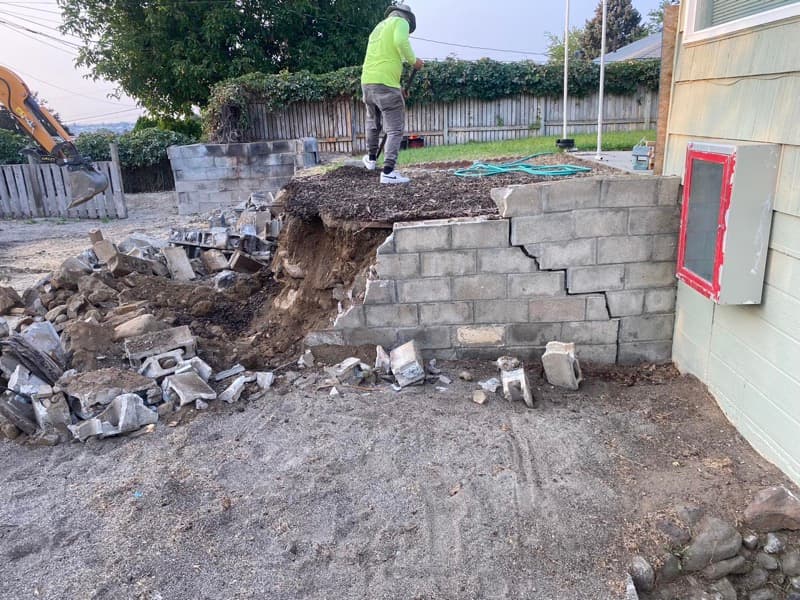 Equipo retirando un muro de bloques derrumbado