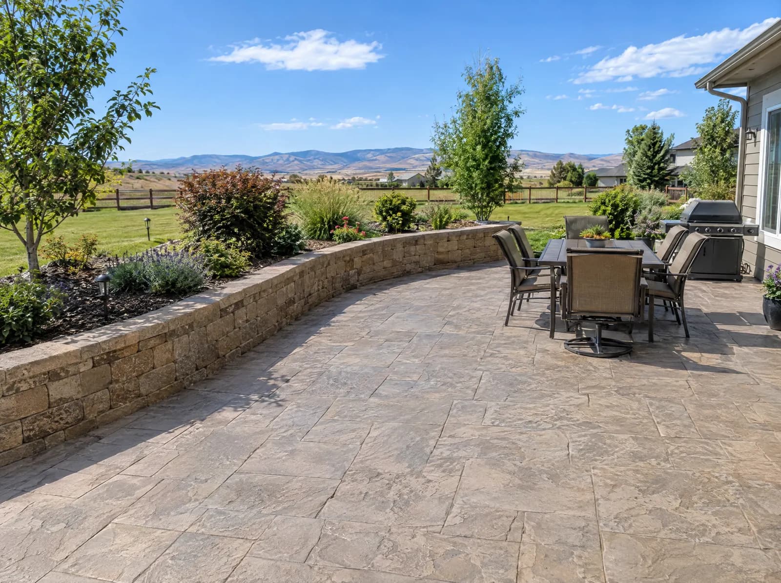 Stamped concrete patio with a curved block retaining wall