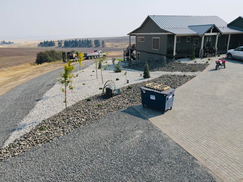 Rock landscaping and a paver driveway at a new home
