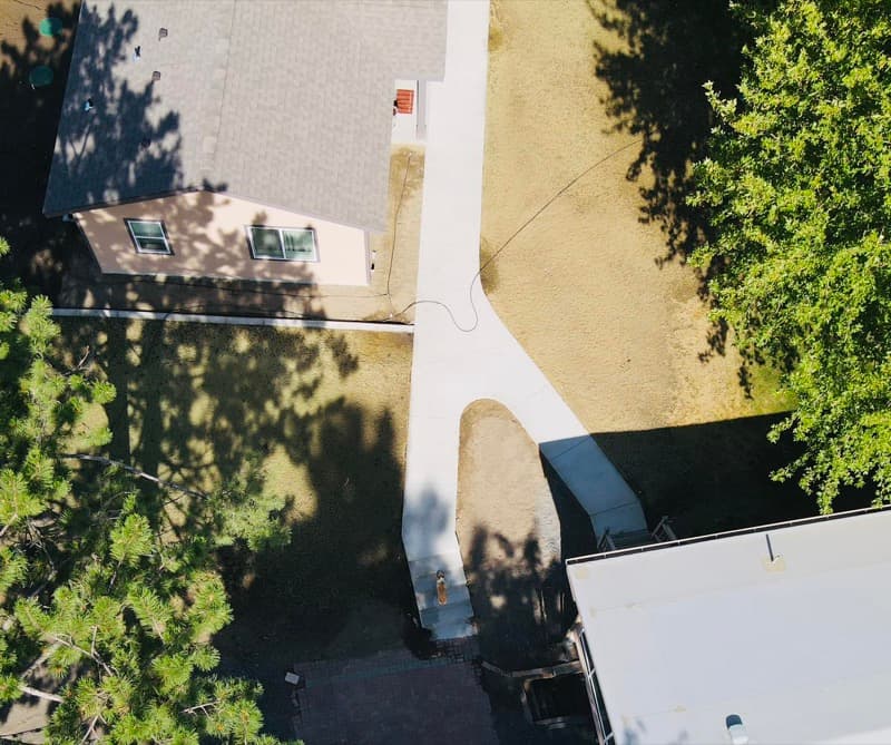 Aerial view of a new concrete walkway to a backyard