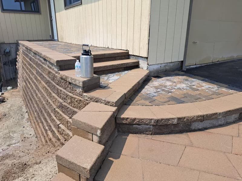 Block retaining wall with paver steps and patio