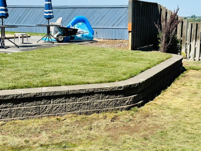 Block retaining wall holding a raised lawn